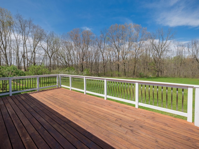 wooden deck featuring a lawn