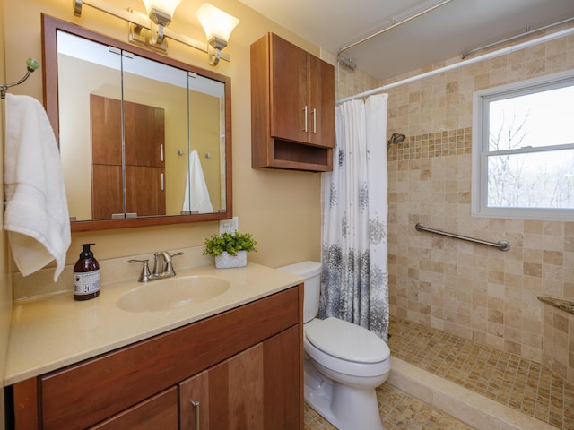 full bathroom featuring vanity, toilet, and tiled shower