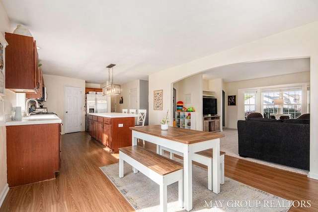 dining area featuring arched walkways and wood finished floors