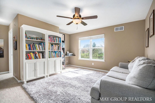 living room with visible vents, a ceiling fan, baseboards, and carpet floors