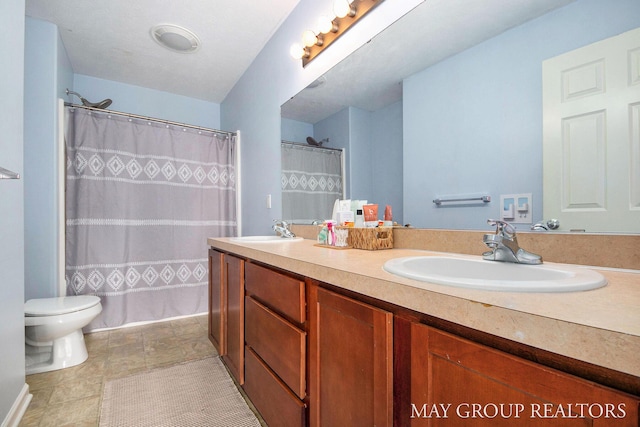 bathroom featuring double vanity, toilet, a shower with curtain, and a sink