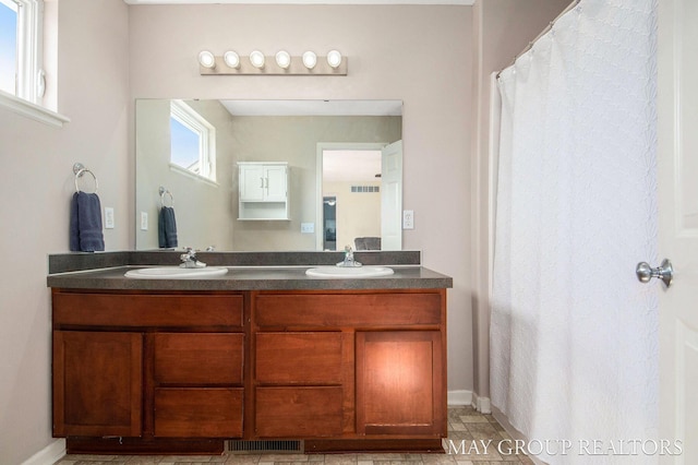 full bathroom with visible vents, a sink, and double vanity