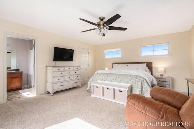 bedroom with baseboards, ceiling fan, light carpet, and ensuite bathroom