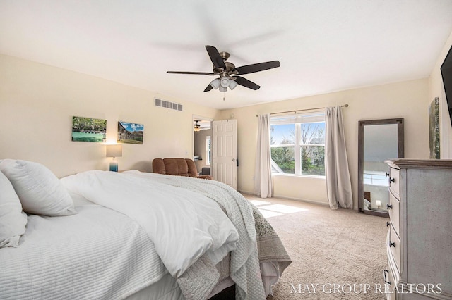 bedroom featuring ceiling fan, visible vents, and light carpet