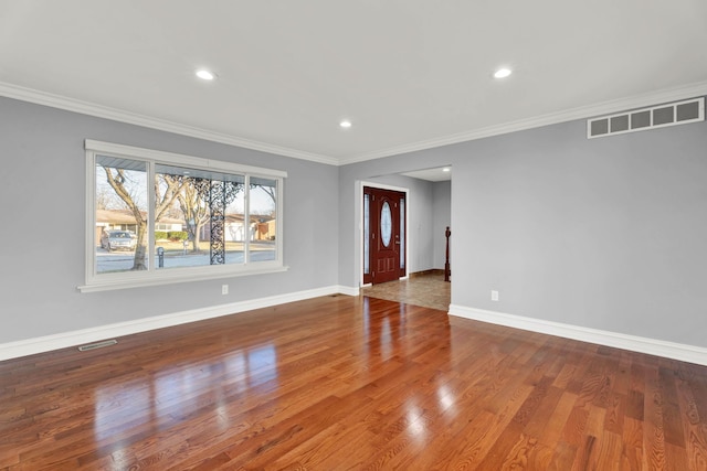 unfurnished living room with baseboards, ornamental molding, and visible vents