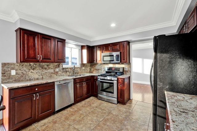 kitchen featuring crown molding, a sink, decorative backsplash, and appliances with stainless steel finishes