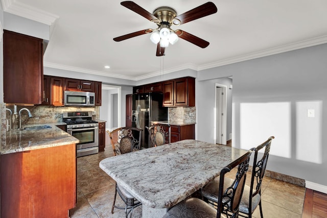 kitchen featuring ceiling fan, tasteful backsplash, a sink, ornamental molding, and stainless steel appliances