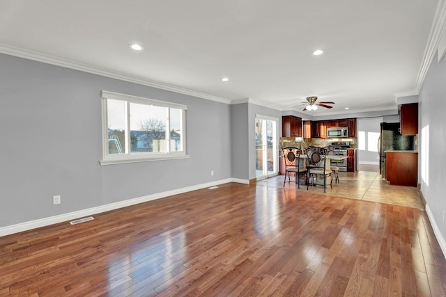 living area featuring recessed lighting, ceiling fan, a wealth of natural light, and hardwood / wood-style flooring