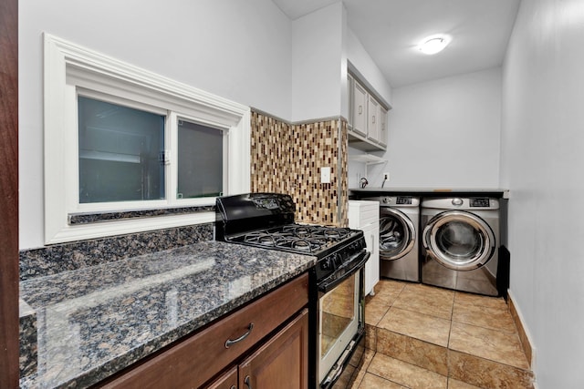 clothes washing area with independent washer and dryer, laundry area, and baseboards