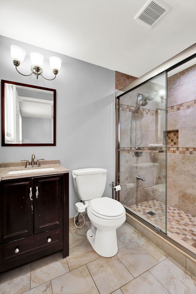 bathroom featuring vanity, a shower stall, toilet, and visible vents