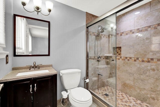 full bath with vanity, a shower stall, and toilet