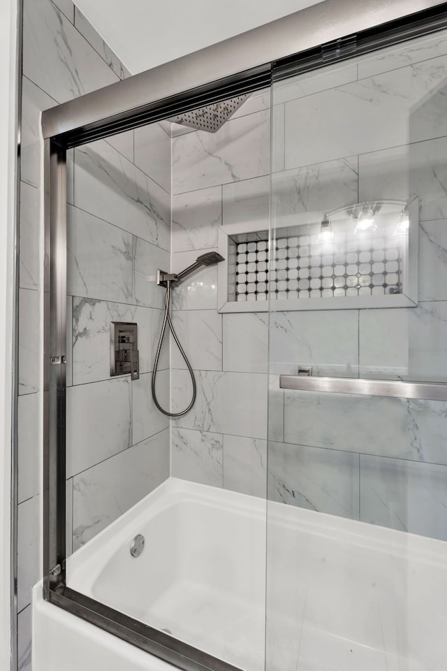 bathroom featuring bath / shower combo with glass door