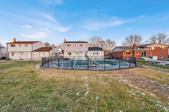 view of pool featuring a lawn, fence, a fenced in pool, and a residential view