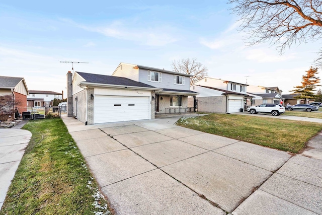 traditional-style house with concrete driveway, an attached garage, a porch, and a front lawn