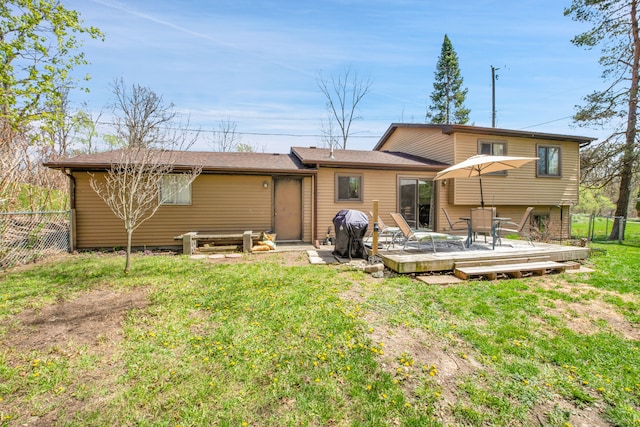 back of house with a yard, a deck, and fence