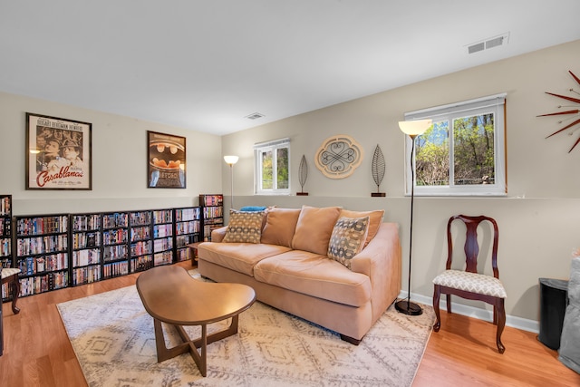 living room featuring baseboards, light wood-type flooring, and visible vents