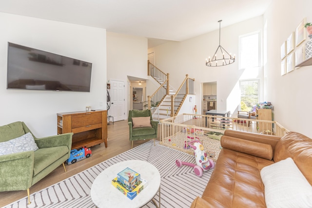 3941 Steamboat Ct, Ann Arbor, MI 48108 - living room with a high ceiling, a notable chandelier, wood finished floors, and stairway