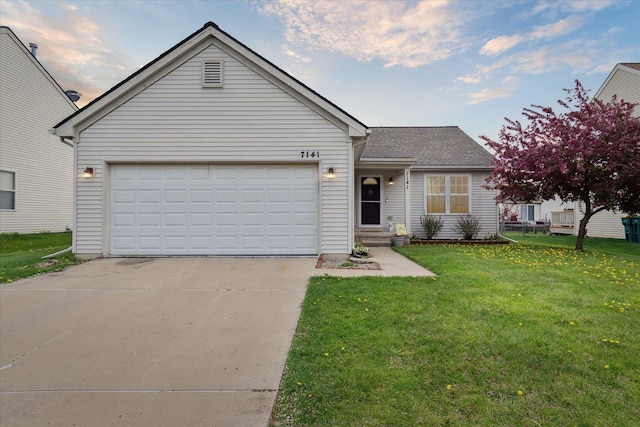 view of front facade featuring a garage, a front yard, and concrete driveway