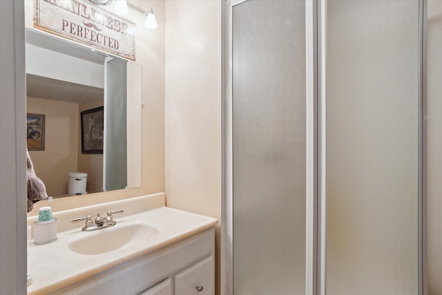 full bath with vanity, a shower stall, and toilet