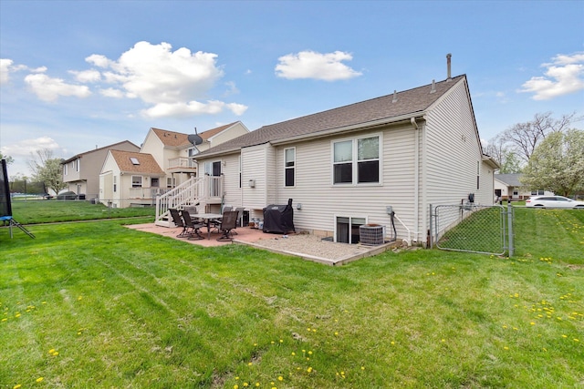 rear view of property featuring a lawn, a gate, a patio area, and central AC