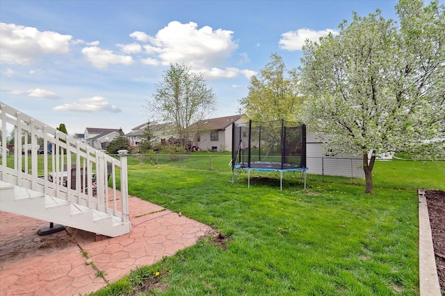 view of yard with a fenced backyard, a trampoline, and a patio area