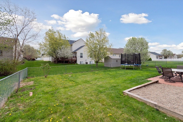 view of yard with a fenced backyard, a trampoline, and a residential view