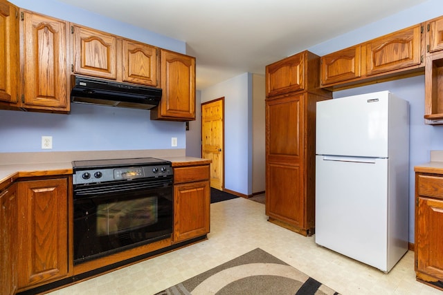 kitchen featuring brown cabinetry, black electric range, light countertops, freestanding refrigerator, and under cabinet range hood