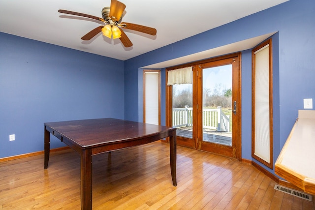 home office featuring baseboards, ceiling fan, light wood-style flooring, and visible vents
