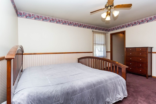 bedroom featuring a ceiling fan, carpet, and wainscoting