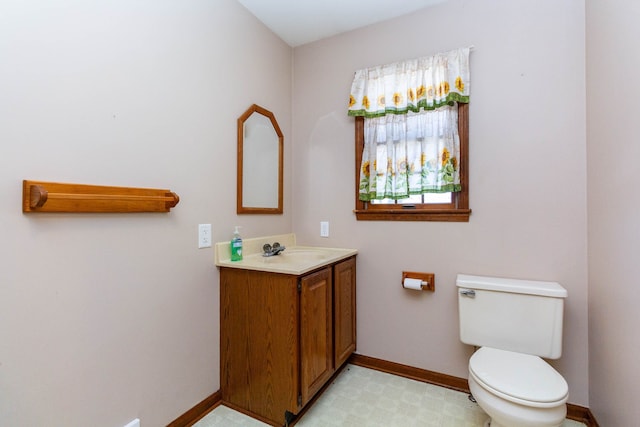 bathroom with baseboards, vanity, and toilet