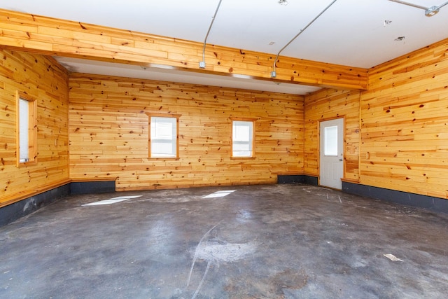 spare room with wooden walls and concrete floors