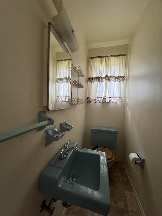 bathroom with baseboards, a sink, and toilet