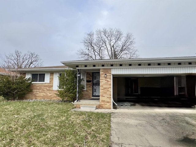 view of front of home with a garage, driveway, a front lawn, and brick siding