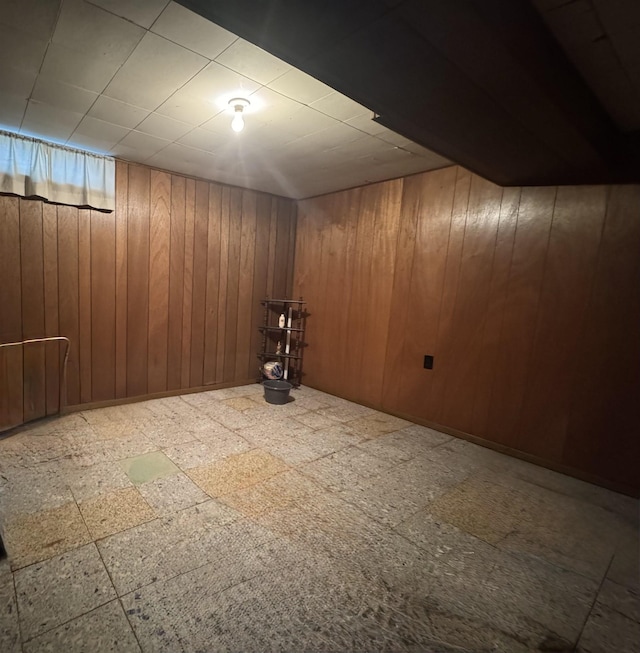 finished basement featuring tile patterned floors and wooden walls
