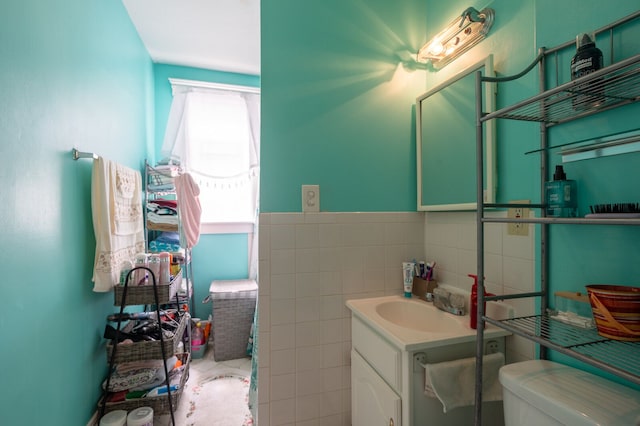 bathroom with tile walls, vanity, and toilet