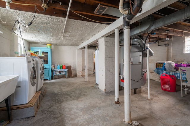 below grade area featuring heating unit and separate washer and dryer