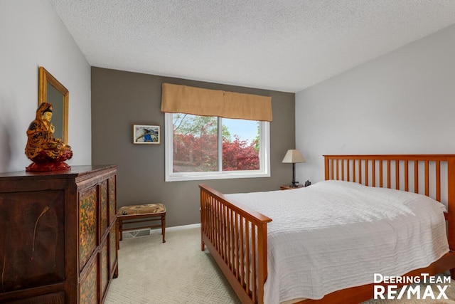 bedroom featuring light colored carpet and a textured ceiling