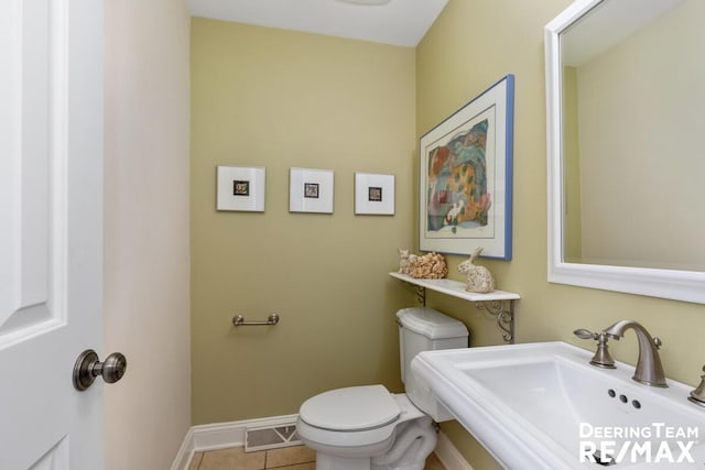 bathroom featuring a sink, tile patterned flooring, toilet, baseboards, and visible vents