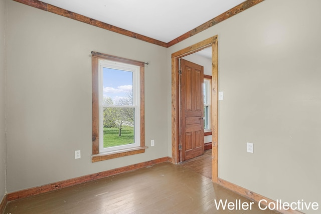 empty room with baseboards and hardwood / wood-style flooring