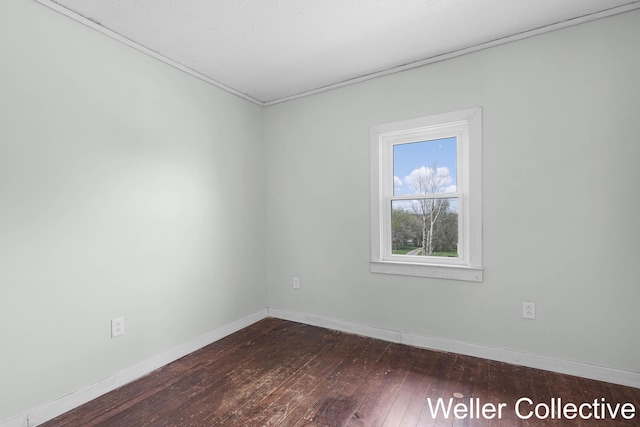 empty room featuring baseboards and dark wood finished floors