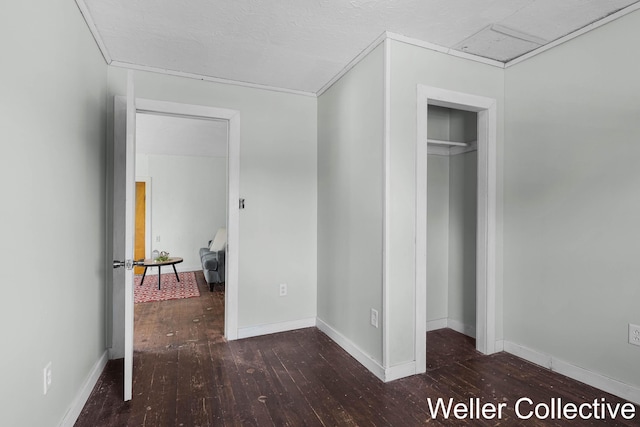 unfurnished bedroom with wood-type flooring, baseboards, and a closet