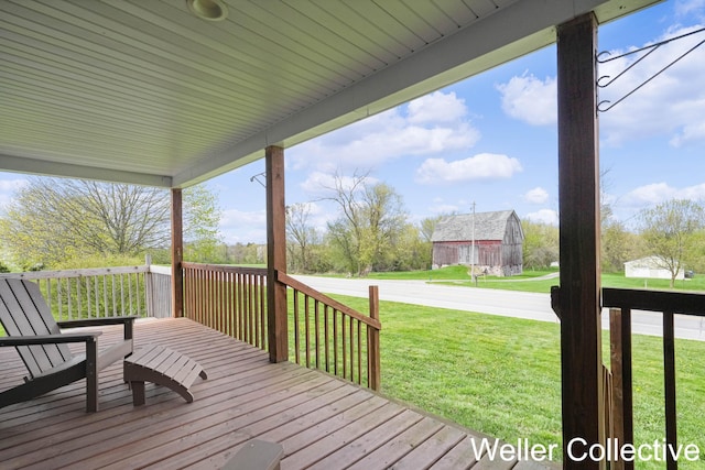 wooden terrace featuring an outbuilding, a barn, and a yard