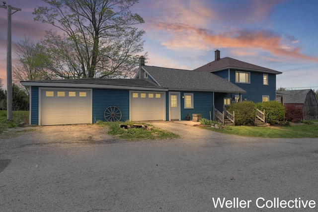 view of front of property with a garage, driveway, and a chimney