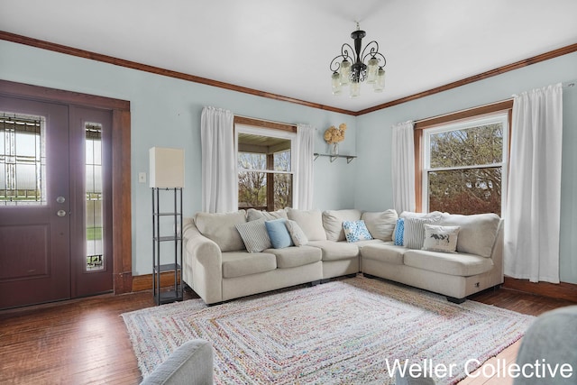 living area featuring crown molding, hardwood / wood-style floors, and a chandelier