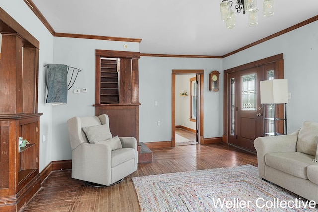 living area featuring baseboards, ornamental molding, and wood finished floors