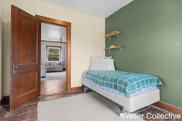 bedroom featuring baseboards and wood finished floors