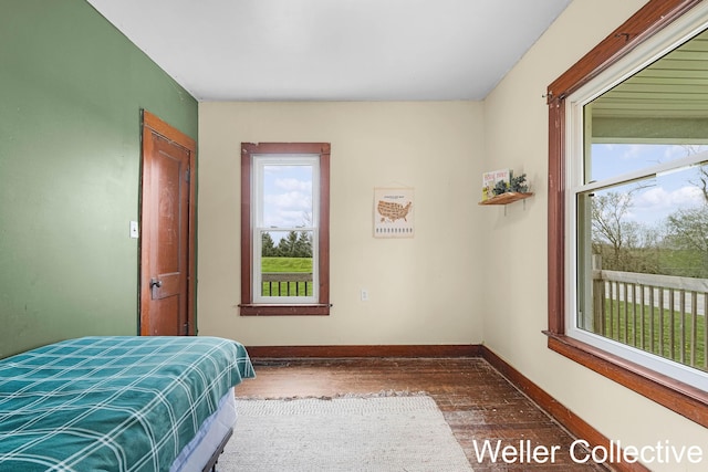 bedroom featuring baseboards and wood finished floors