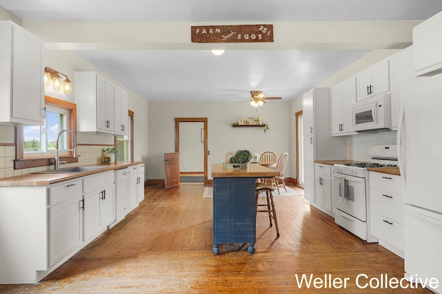 kitchen with white cabinets, ceiling fan, a sink, white appliances, and backsplash