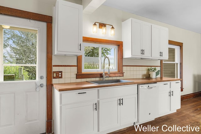 kitchen with butcher block countertops, plenty of natural light, a sink, and dishwasher