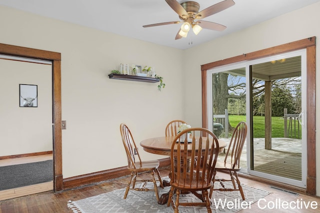 dining space featuring baseboards, ceiling fan, wood-type flooring, and visible vents